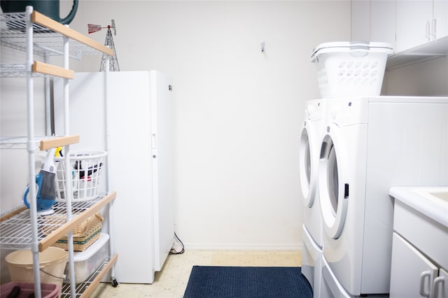 laundry room featuring cabinets and washing machine and dryer