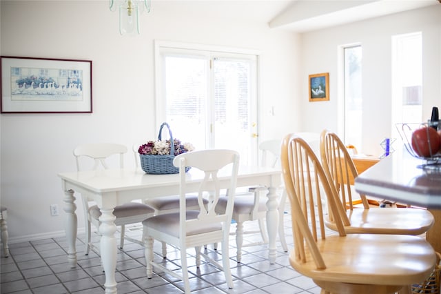 tiled dining room with a notable chandelier