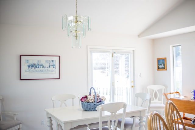 dining area featuring a notable chandelier and vaulted ceiling