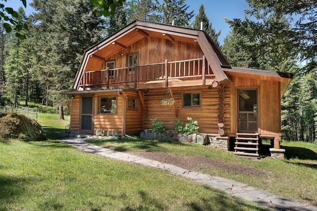 view of front of home featuring a balcony and a front lawn