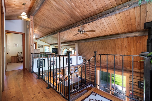 corridor featuring vaulted ceiling with beams, wood-type flooring, wood ceiling, and wooden walls