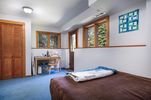 bedroom featuring built in desk, carpet flooring, and a closet