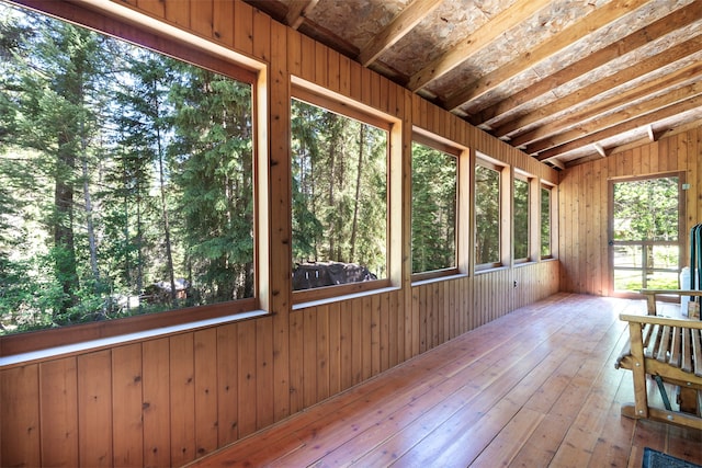 unfurnished sunroom with vaulted ceiling with beams