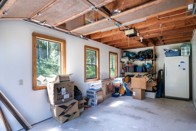 garage with a garage door opener and white fridge