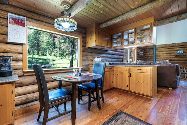 dining space featuring rustic walls, wood ceiling, dark hardwood / wood-style floors, and beam ceiling