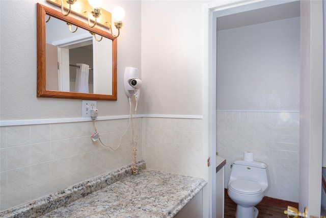 bathroom featuring hardwood / wood-style flooring, tile walls, and toilet