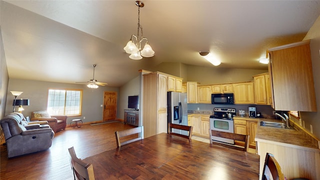 kitchen featuring hanging light fixtures, sink, dark wood-type flooring, stainless steel appliances, and vaulted ceiling