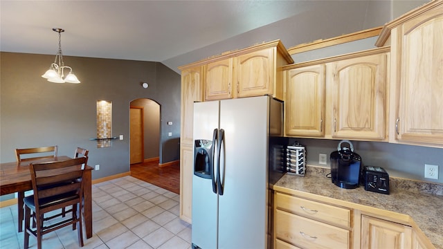 kitchen with an inviting chandelier, light brown cabinets, hanging light fixtures, stainless steel refrigerator with ice dispenser, and light tile patterned floors