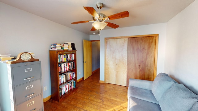 living area featuring wood-type flooring and ceiling fan