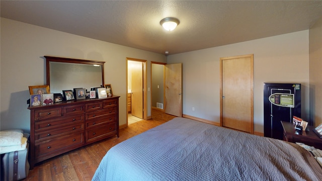 bedroom featuring hardwood / wood-style flooring and a textured ceiling