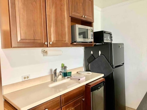 180 Vista Ln Unit 258, Bigfork, MT 59911 - kitchen with stainless steel appliances, light countertops, brown cabinets, and crown molding