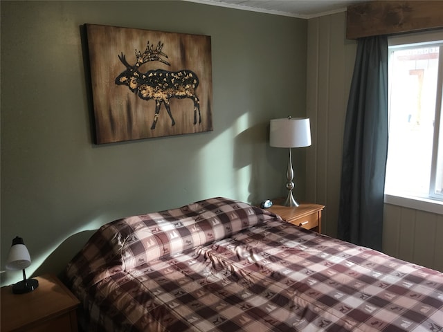 bedroom with ornamental molding and multiple windows