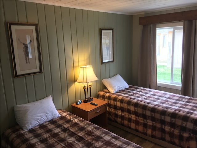 bedroom featuring hardwood / wood-style floors and wooden walls