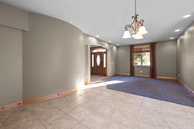 foyer with light tile patterned flooring and a chandelier