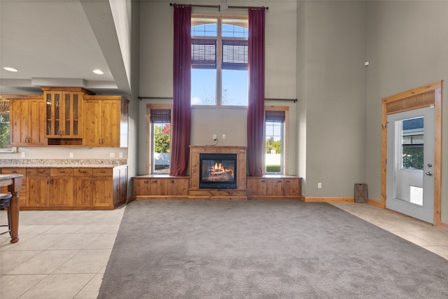 unfurnished living room featuring light tile patterned flooring and plenty of natural light