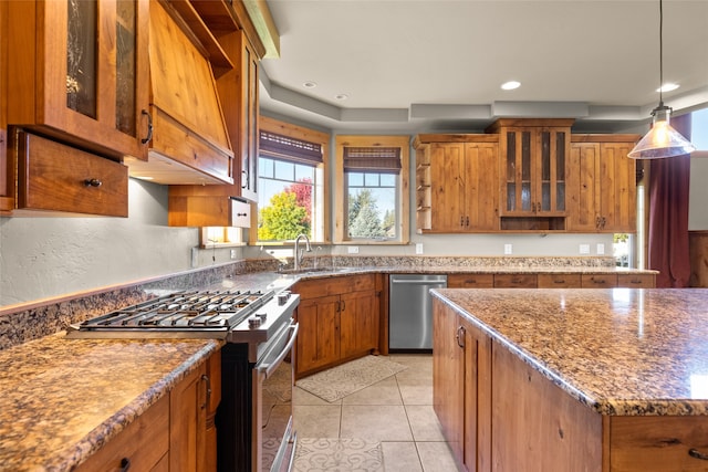 kitchen featuring dark stone counters, stainless steel appliances, light tile patterned floors, and sink