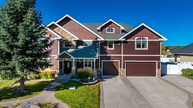 craftsman inspired home with a garage and a front lawn