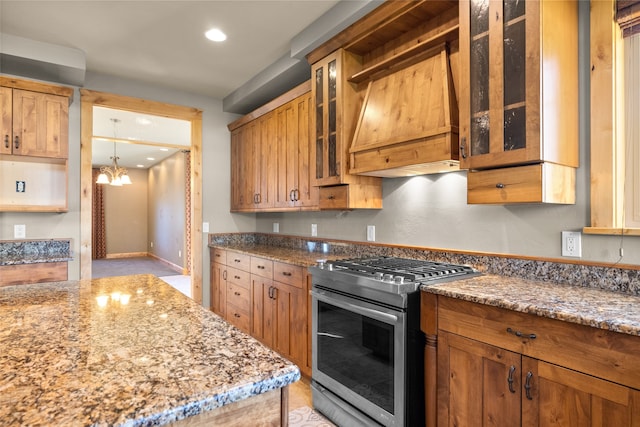 kitchen featuring a notable chandelier, gas stove, light stone countertops, and custom exhaust hood