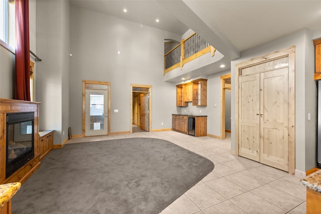 living room with light carpet, wine cooler, and a high ceiling