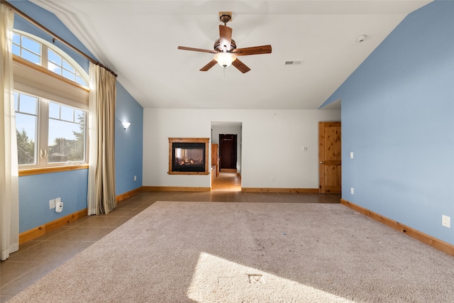 unfurnished living room with vaulted ceiling, ceiling fan, and light tile patterned floors