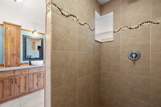 bathroom featuring vanity, tile patterned flooring, and a tile shower