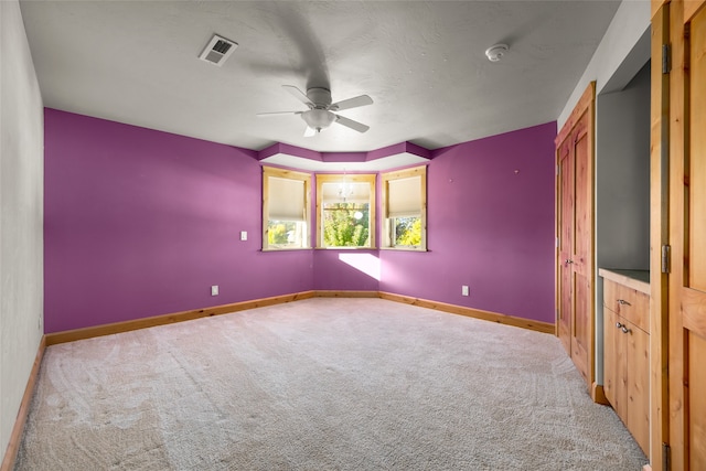 carpeted empty room featuring ceiling fan