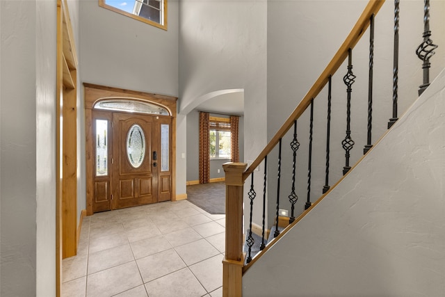 entrance foyer with light tile patterned floors and a high ceiling