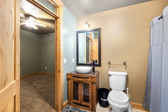 bathroom featuring ceiling fan, vanity, toilet, walk in shower, and tile patterned flooring