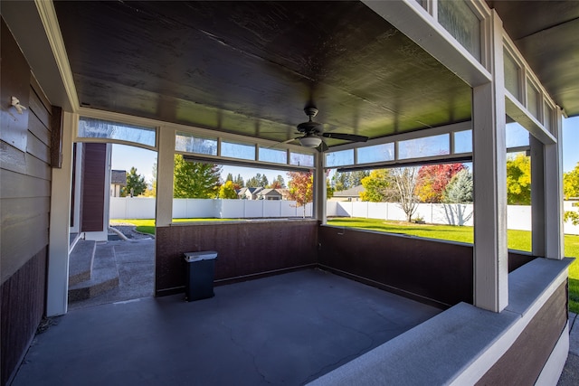 unfurnished sunroom with ceiling fan