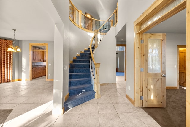 stairs with tile patterned flooring and a chandelier