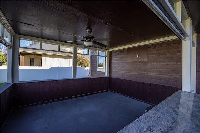 unfurnished sunroom featuring ceiling fan and a healthy amount of sunlight