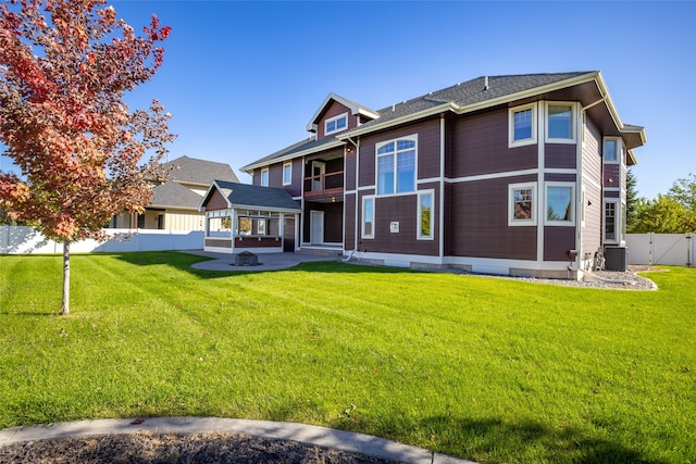 rear view of property with central AC unit and a lawn