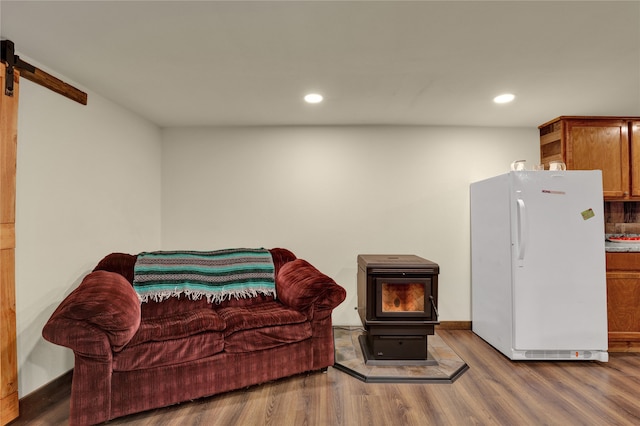 sitting room with a wood stove and hardwood / wood-style flooring