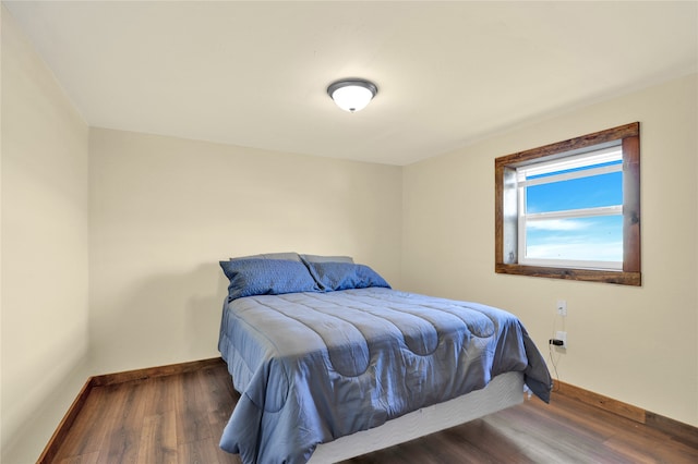 bedroom with dark hardwood / wood-style flooring