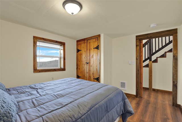 bedroom with dark hardwood / wood-style flooring