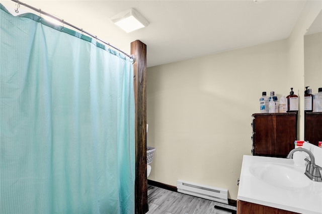 bathroom featuring baseboard heating, hardwood / wood-style floors, and vanity