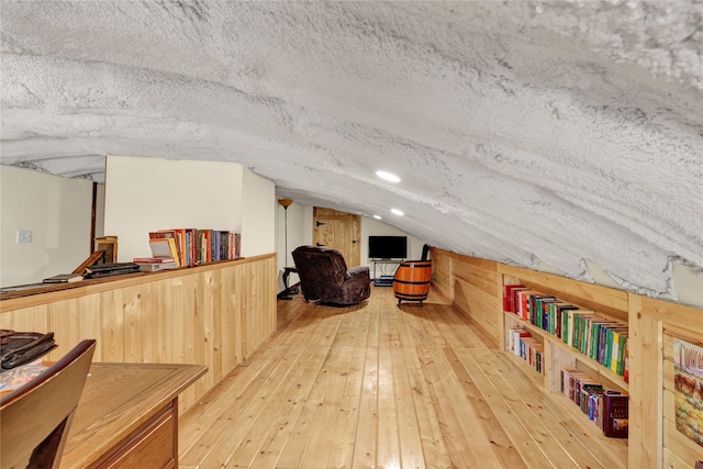 bonus room featuring vaulted ceiling, hardwood / wood-style floors, and a textured ceiling