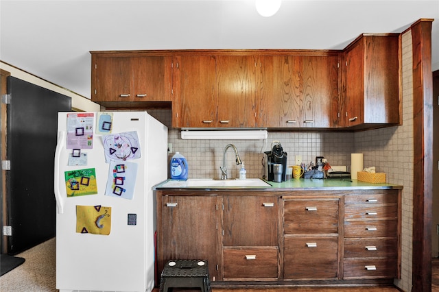 kitchen featuring decorative backsplash, sink, and white fridge