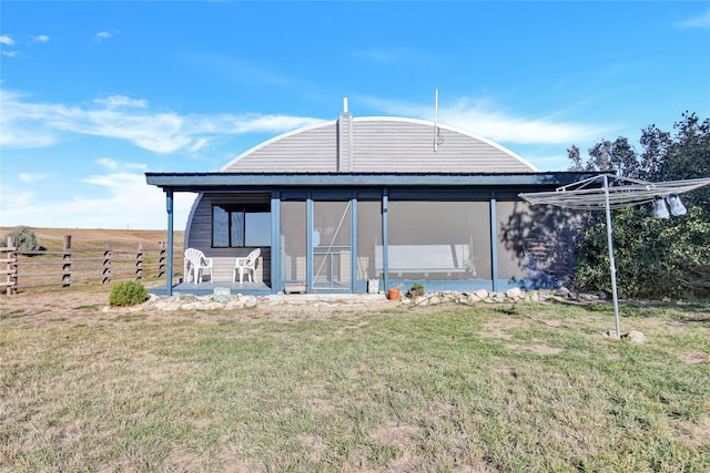 rear view of house featuring a lawn