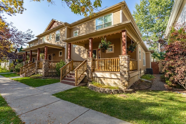 craftsman inspired home featuring central AC unit, a front yard, and covered porch