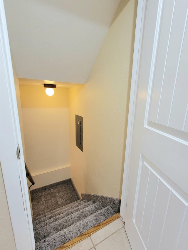 staircase with electric panel and tile patterned floors