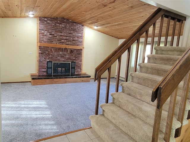 staircase with carpet flooring, wood ceiling, lofted ceiling, and a brick fireplace