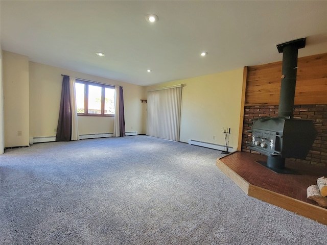 unfurnished living room featuring baseboard heating, a wood stove, and carpet floors