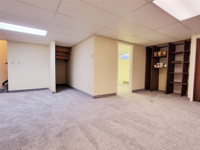 basement with a drop ceiling, carpet floors, and baseboard heating