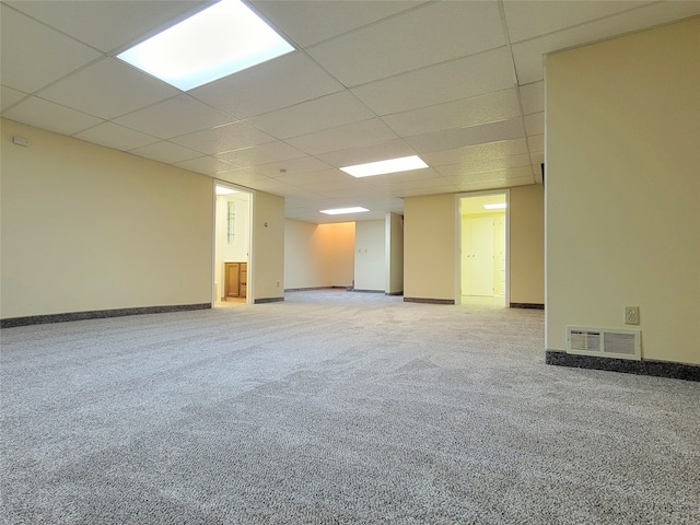 carpeted spare room featuring a drop ceiling