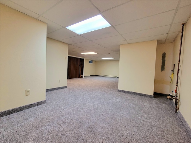 basement with carpet flooring, a paneled ceiling, and a baseboard radiator