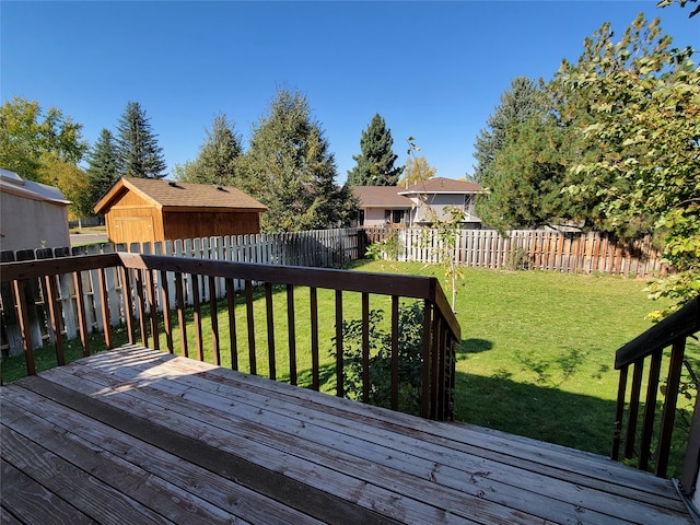 wooden terrace featuring a yard and a shed