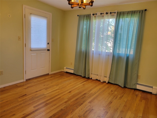 interior space featuring a baseboard heating unit, light hardwood / wood-style flooring, and a notable chandelier