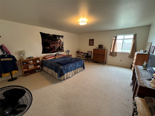 bedroom featuring light colored carpet and a textured ceiling