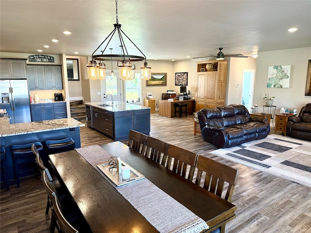 dining space with ceiling fan, sink, and hardwood / wood-style floors